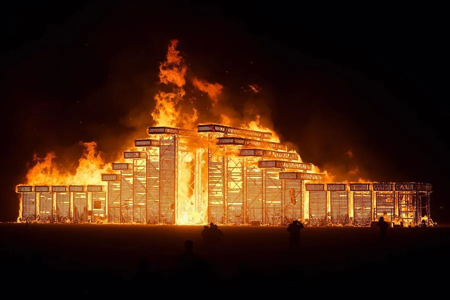 The wooden Temple burns against the night sky