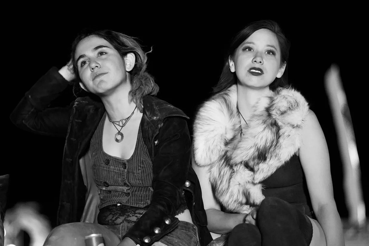 Black-and-white portrait of two women seated side by side and looking upward