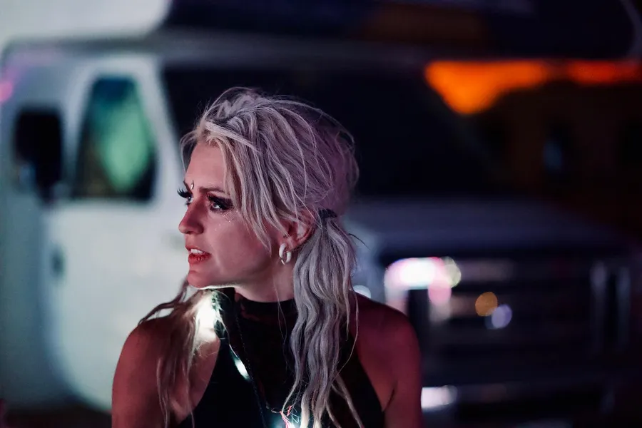 Night portrait of a woman with long pale hair and a reflective black top