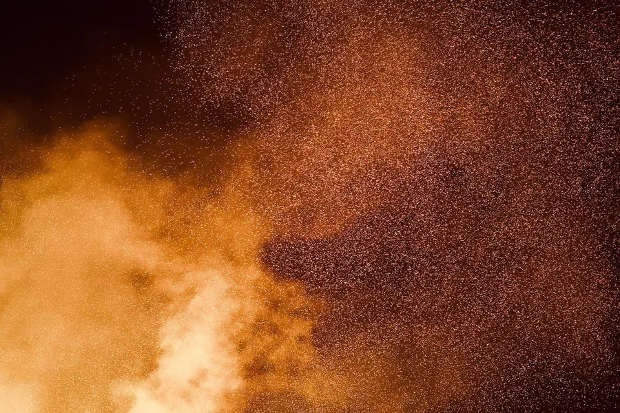 Orange flames and a cloud of sparks fill the night