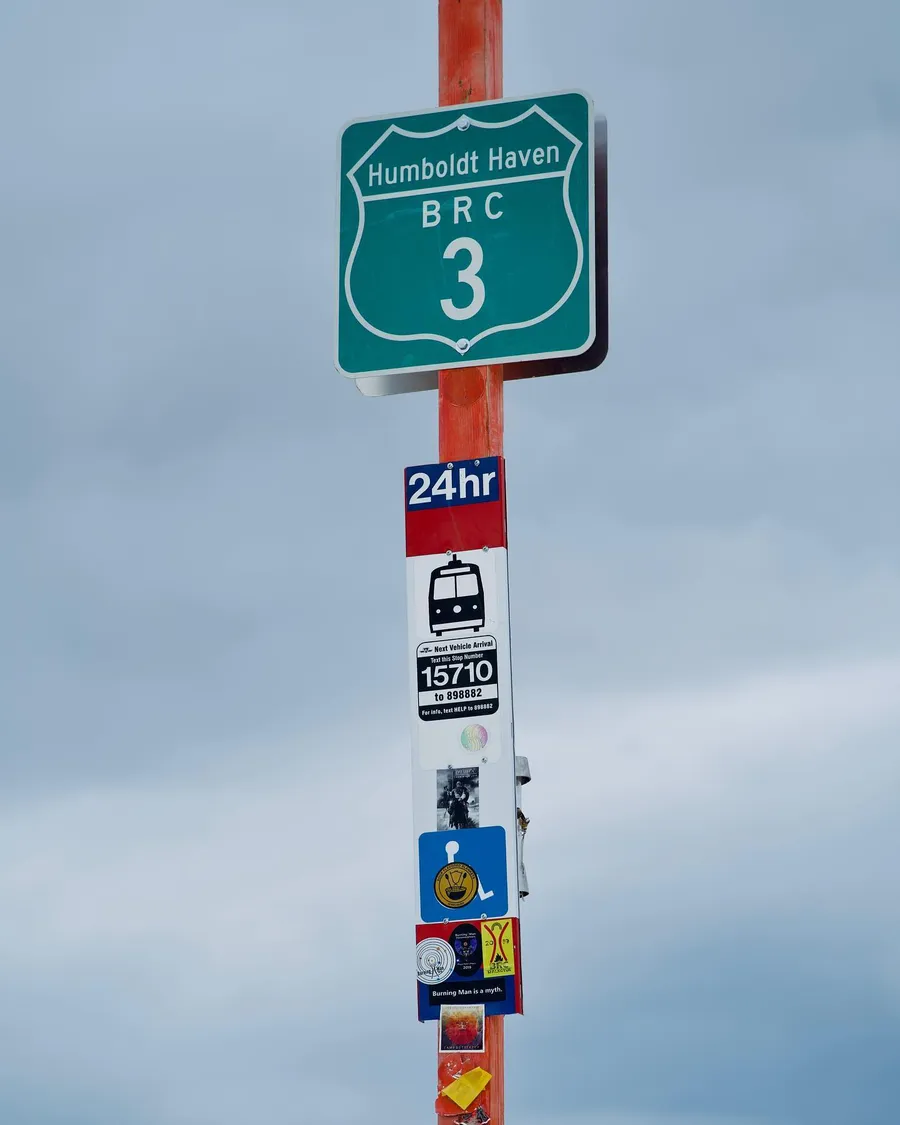 A sticker-covered street sign reading “Humboldt Raven BRC 3” stands against the sky