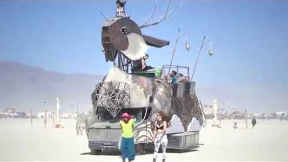 Tarna the Jackalope carries riders across the playa as two people walk in front