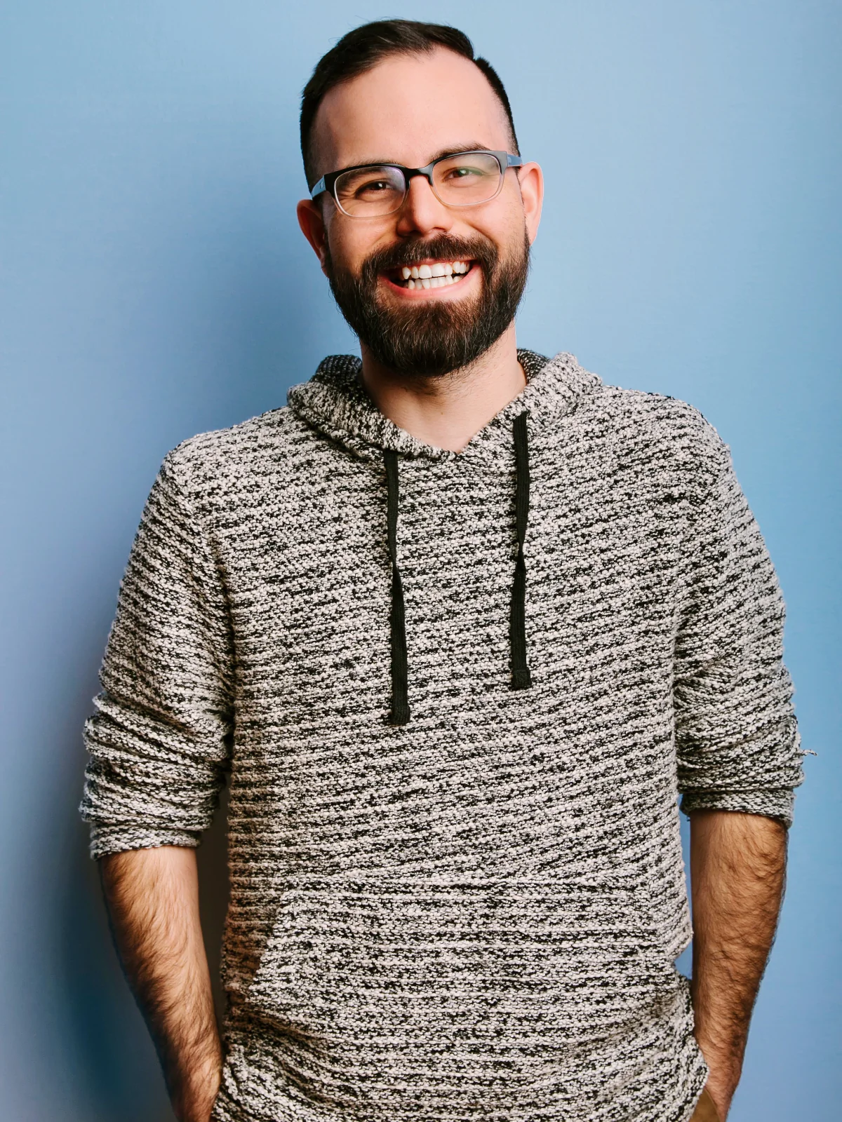 Justin smiling against a blue background